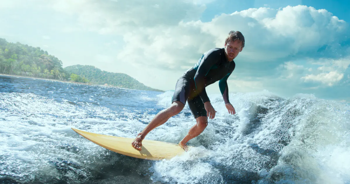 Guy surfing on small ocean wave